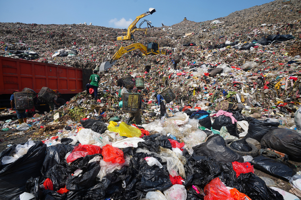 Waste pickers look for recyclable items in a pile of garbage at the Bantargebang landfill on the outskirts of Jakarta, Indonesia, Monday, July 6, 2026. (AP Photo/Tatan Syuflana)
