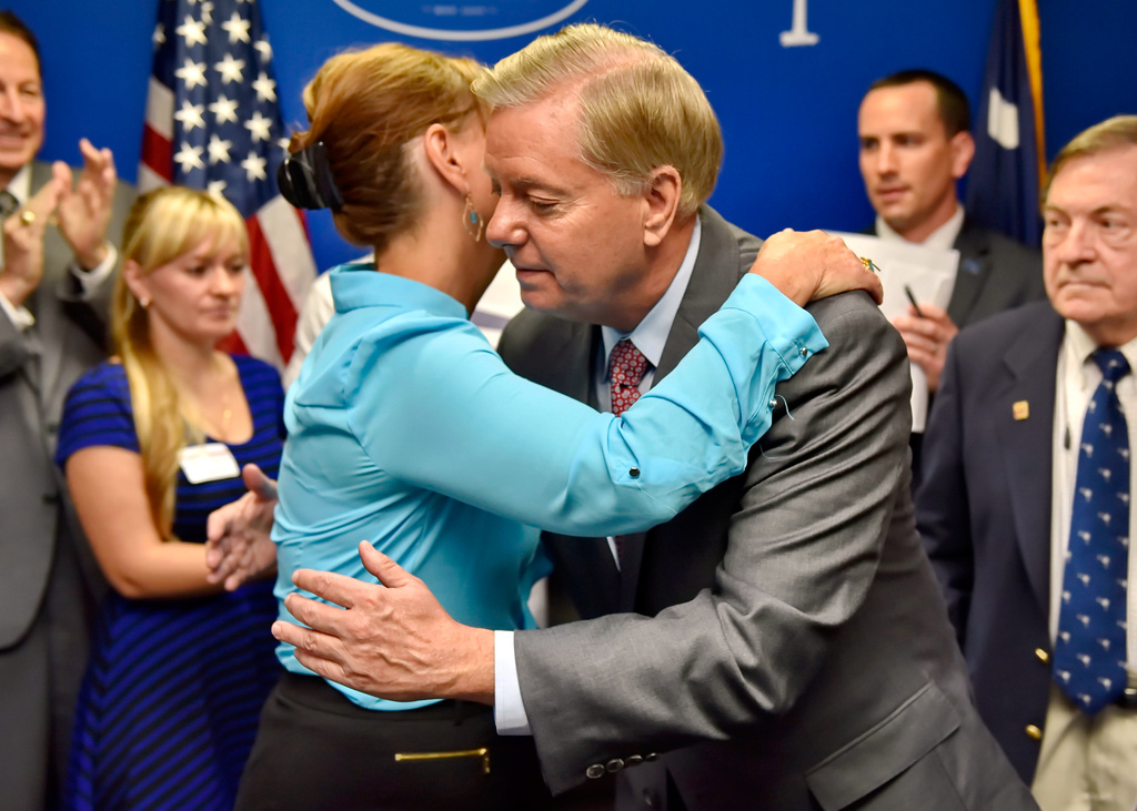 FILE - Republican presidential candidate, Sen. Lindsey Graham, R-S.C., right, hugs his sister Darline Graham after filing for the South Carolina presidential primary, Sept. 1, 2015, at the GOP headquarters in Columbia, S.C. (AP Photo/Richard Shiro, File)