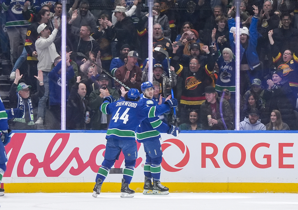 Vancouver Canucks' Linus Karlsson, back right, celebrates his goal with teammate Kiefer Sherwood during the first period of an NHL hockey game against the Colorado Avalanche, in Vancouver, B.C., Sunday, Nov. 9, 2025. (Darryl Dyck/The Canadian Press via AP)