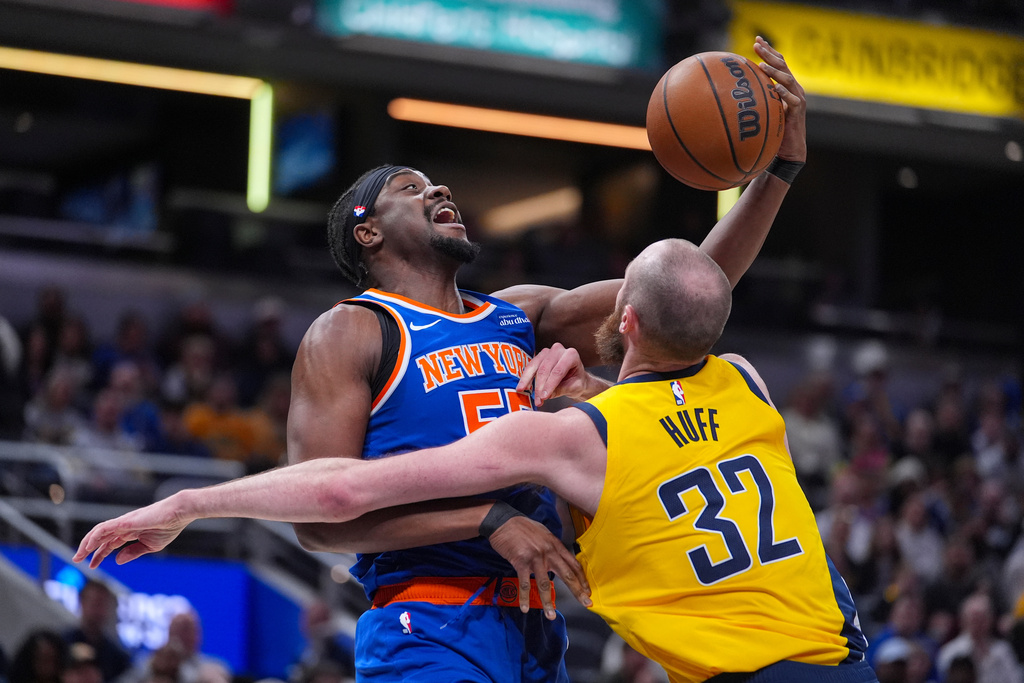 New York Knicks center Ariel Hukporti (55) grabs a rebound over Indiana Pacers center Jay Huff (32) during the first half of an NBA basketball game in Indianapolis, Friday, March 13, 2026. (AP Photo/Michael Conroy)