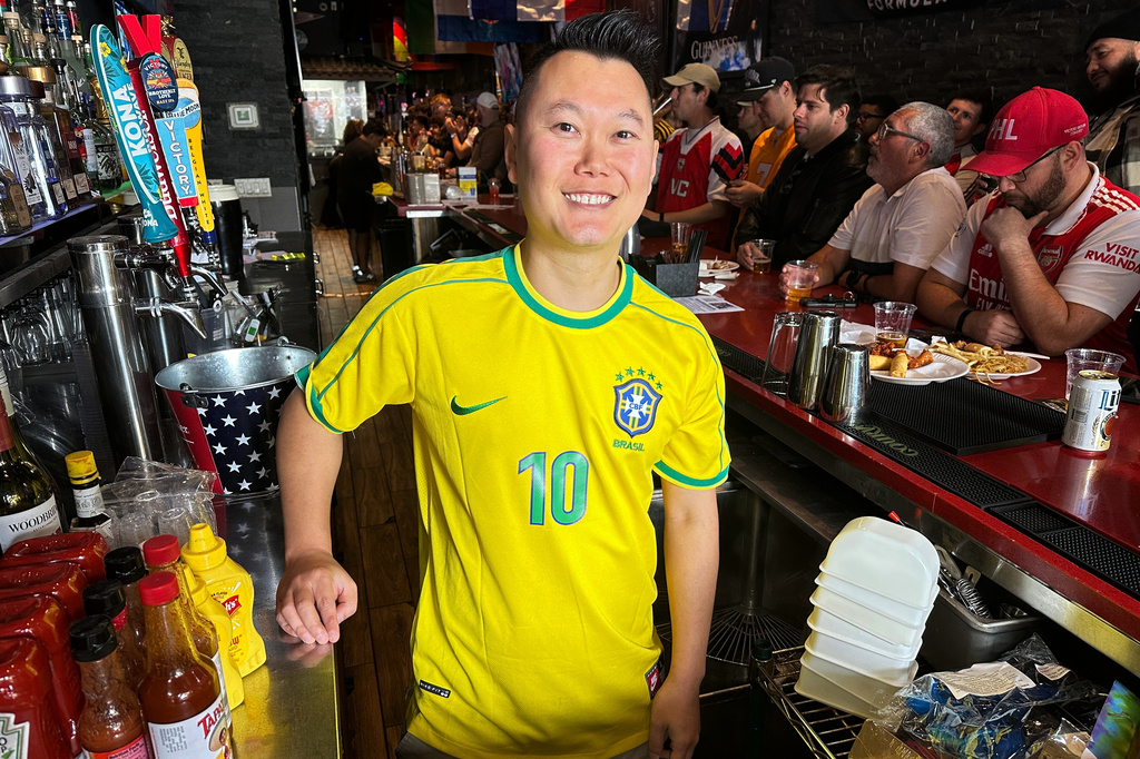 Lion Sports Bar owner Mark Prinzinger poses behind the bar as fans watch a Champion league soccer match between Arsenal and Paris Saint-Germain, Saturday, May 30, 2026, in Philadelphia. (AP Photo/Tassanee Vejpongsa)