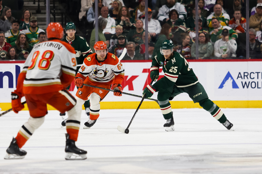 Minnesota Wild's Jonas Brodin (25) controls the puck past Anaheim Ducks' Mikael Granlund (64) during the third period of an NHL hockey game Tuesday, April 14, 2026, in St. Paul, Minn. (AP Photo/Lily Dozier)