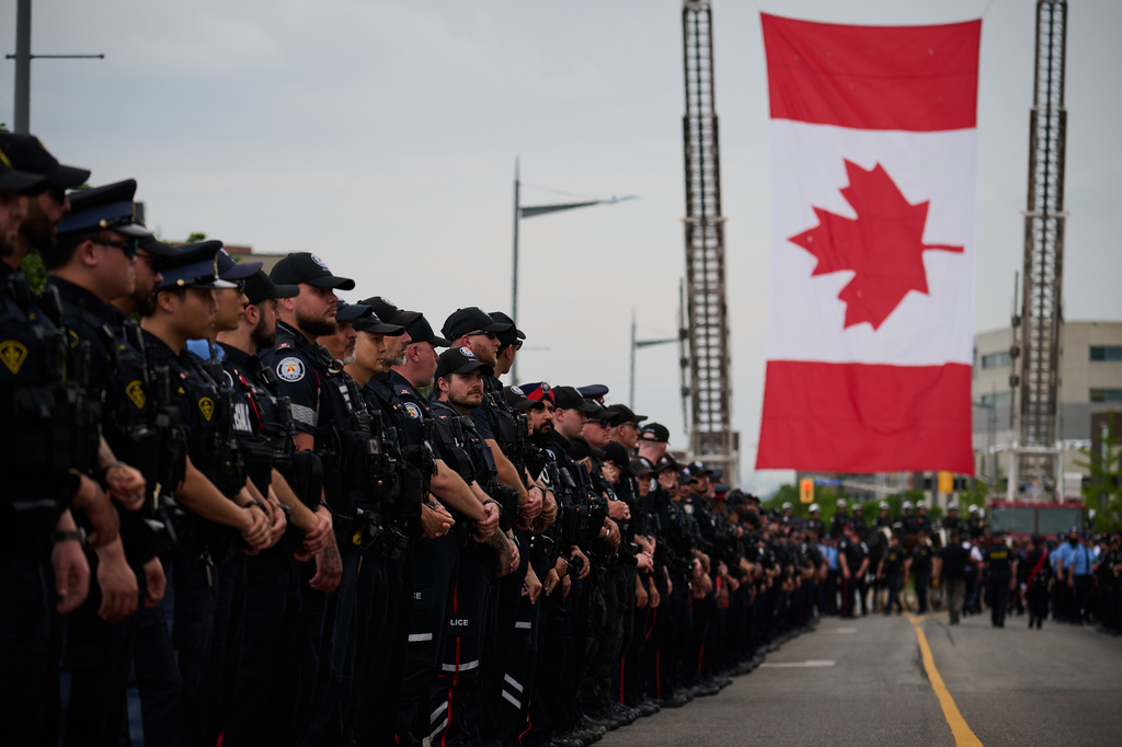 Police stand by for the arrival of a procession with the body of Toronto Police Const. Marc Pinizzotto, who was killed in the line of duty, at the Chief Coroner's office in Toronto, Thursday, June 11, 2026. (Sammy Kogan/The Canadian Press via AP)
