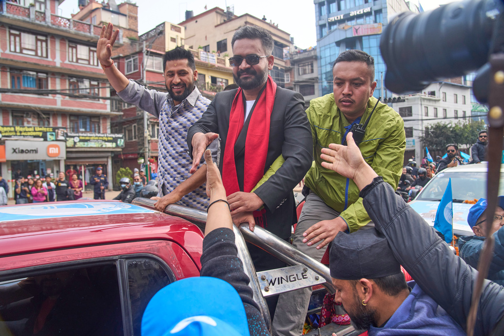Balendra Shah, right, former mayor of Kathmandu Metropolitan City and prime ministerial candidate of the Rastriya Swatantra Party, center, greets people during a road show ahead of national election in Lalitpur, Nepal, Saturday, Feb. 28, 2026. (AP Photo/Niranjan Shrestha)