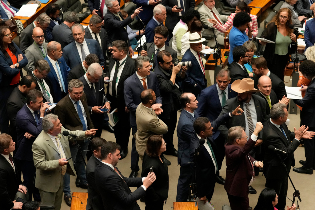 Congresspeople from parties supporting former President Jair Bolsonaro, sentenced for leading a coup attempt, attend a session to consider a bill to alter sentencing guidelines for certain crimes including coups d'état, in Brasilia, Brazil, Tuesday, Dec. 9, 2025. (AP Photo/Eraldo Peres)