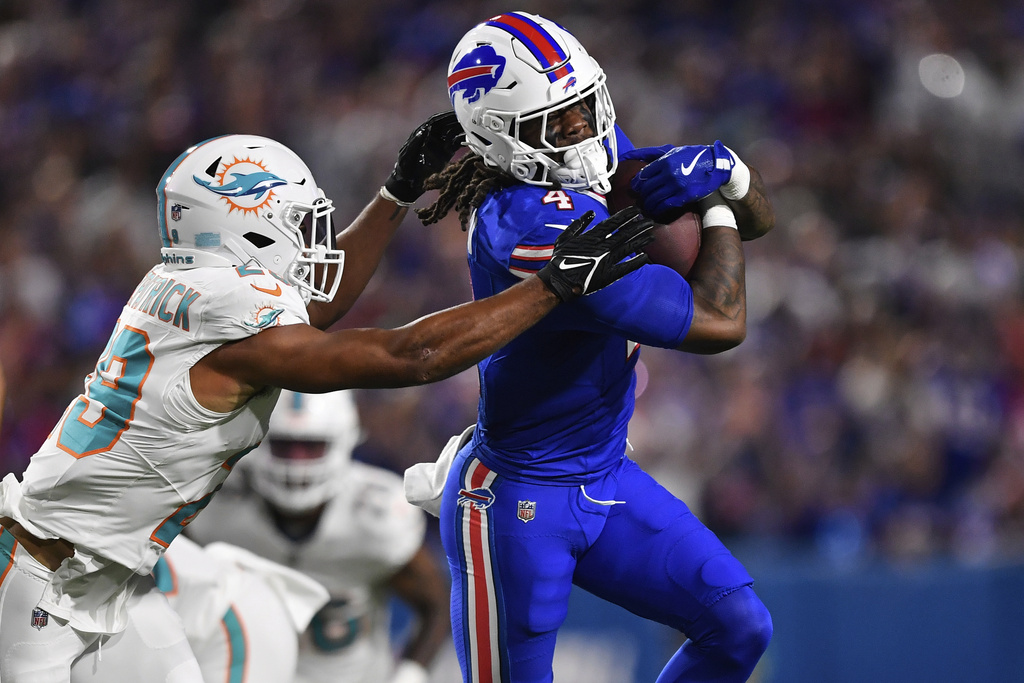 Miami Dolphins free safety Minkah Fitzpatrick, left, tackles Buffalo Bills running back James Cook during the first half of an NFL football game, Thursday, Sept. 18, 2025, in Orchard Park, N.Y. (AP Photo/Adrian Kraus)
