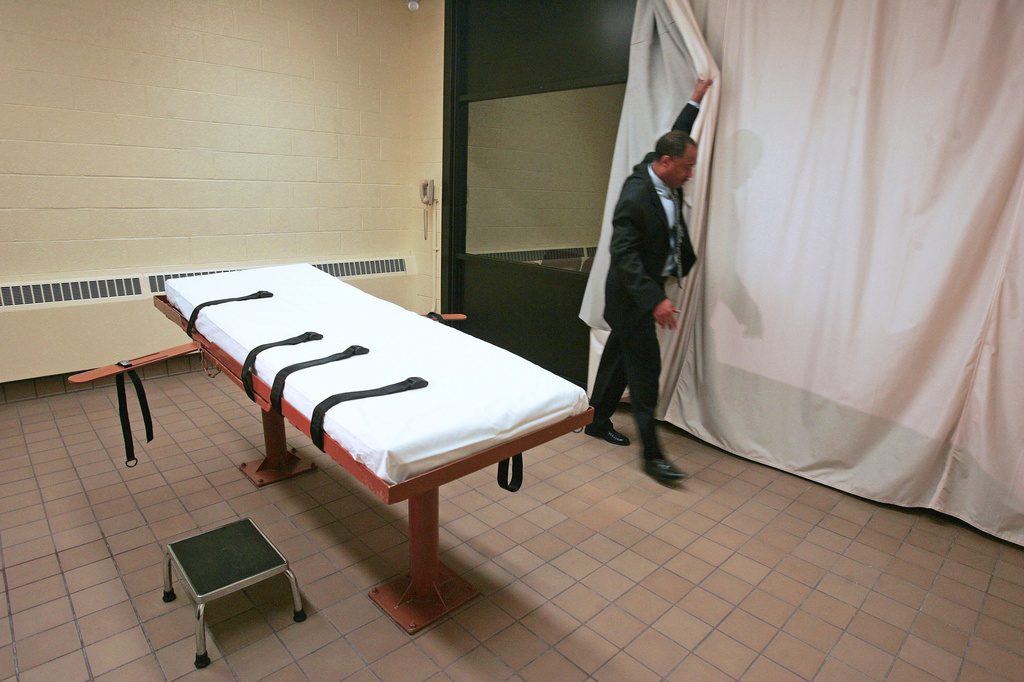 FILE – Larry Greene, public information director of the Southern Ohio Correctional Facility, demonstrates how a curtain is pulled between the death chamber and witness room at the prison in Lucasville, Ohio, in Nov., 2005. (AP Photo/Kiichiro Sato, File)