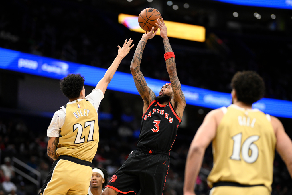 Toronto Raptors forward Brandon Ingram (3) goes up to shoot against Washington Wizards guard Will Riley (27) and forward Anthony Gill (16) during the first half of an NBA basketball game, Saturday, Feb. 28, 2026, in Washington. (AP Photo/Nick Wass)