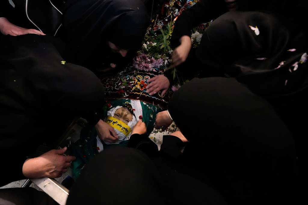 Mourners gather over the body of Jawad Younes, 11, who was killed in an Israeli airstrike during his funeral procession in Saksakieh village, south Lebanon, Saturday, March 28, 2026. (AP Photo/Hussein Malla)