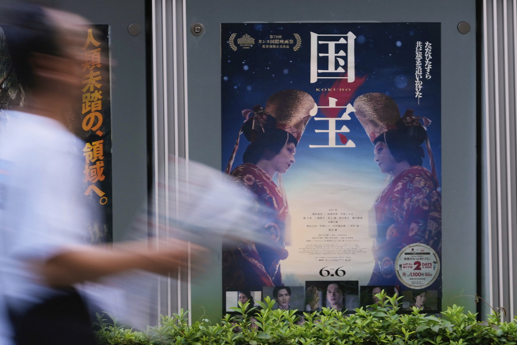 A person walks by a poster of film "Kokuho," in Tokyo, on Aug. 29, 2025. (AP Photo/Shuji Kajiyama)