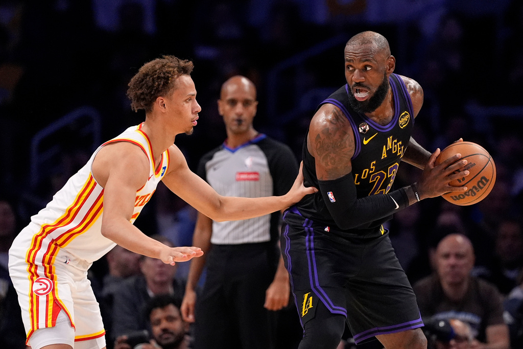 Los Angeles Lakers forward LeBron James, right, tries to get past Atlanta Hawks guard Dyson Daniels during the first half of an NBA basketball game Tuesday, Jan. 13, 2026, in Los Angeles. (AP Photo/Mark J. Terrill)