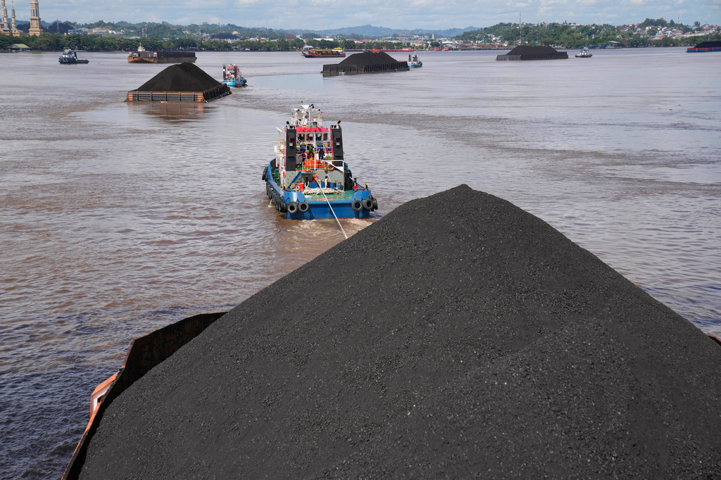 FILE - Tug boats pull barges fully loaded with coal on the Mahakam river in Samarinda, East Kalimantan, Indonesia, on Dec. 19, 2022. (AP Photo/Dita Alangkara, File)