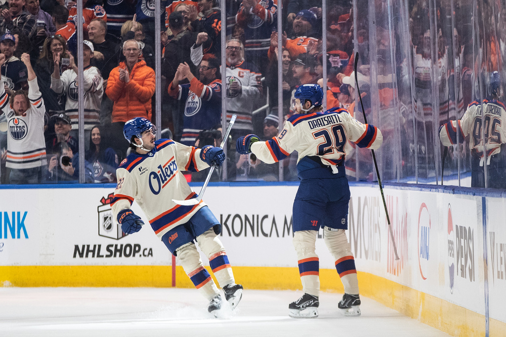 Edmonton Oilers' Matt Savoie, left, and Leon Draisaitl (29) celebrate after a goal against the Winnipeg Jets during first-period NHL hockey game action in Edmonton, Alberta, Saturday, Dec. 6, 2025. (Jason Franson/The Canadian Press via AP)