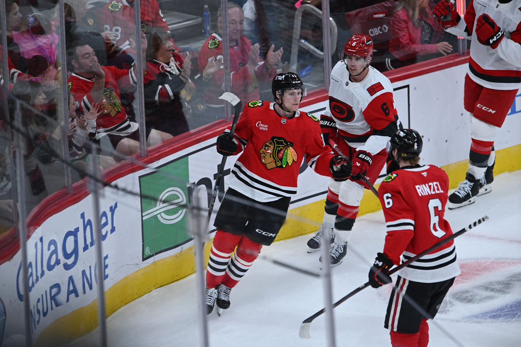 Chicago Blackhawks' Oliver Moore (11) celebrates with teammate Sam Rinzel (6) after scoring a goal during the second period of a NHL hockey game against the Carolina Hurricanes Saturday, Oct. 10, 2026, in Chicago. (AP Photo/Paul Beaty)