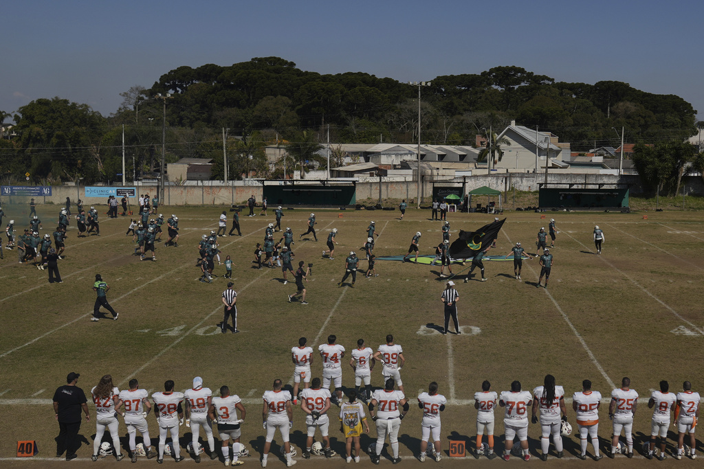 Players of the Coritiba Crocodiles football team, top, enter the field to play the Brown Spiders in Curitiba, Brazil, Sunday, Aug. 17, 2025. (AP Photo/Andre Penner)