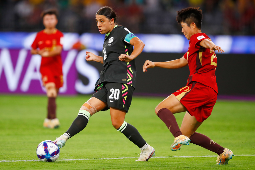 Australia's Sam Kerr passes the ball as China's Zhang Chengxue, right, watches during the Women's Asian Cup semifinal soccer match between China and Australia in Perth, Australia, Tuesday, March 17, 2026. (AP Photo/Gary Day)