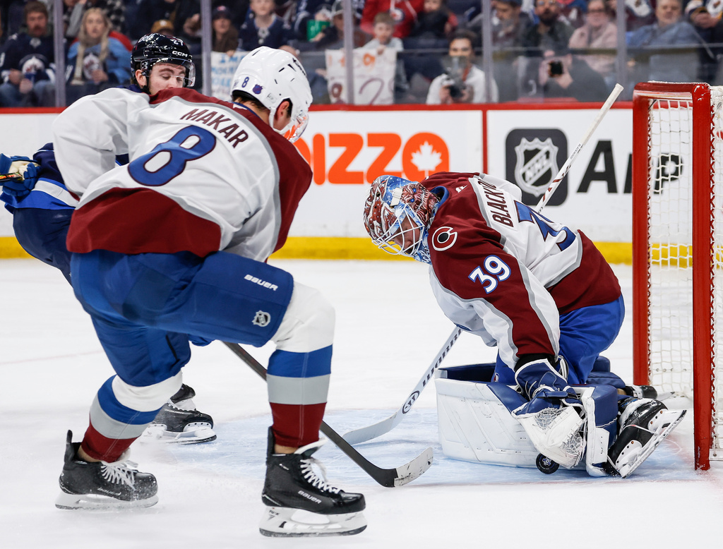 Colorado Avalanche's goaltender Mackenzie Blackwood (39) saves the shot from Winnipeg Jets' Isak Rosen (27) as Cale Makar (8) defends during the second period of an NHL hockey game, in Winnipeg, Manitoba, Thursday, March 26, 2026. (John Woods/The Canadian Press via AP)