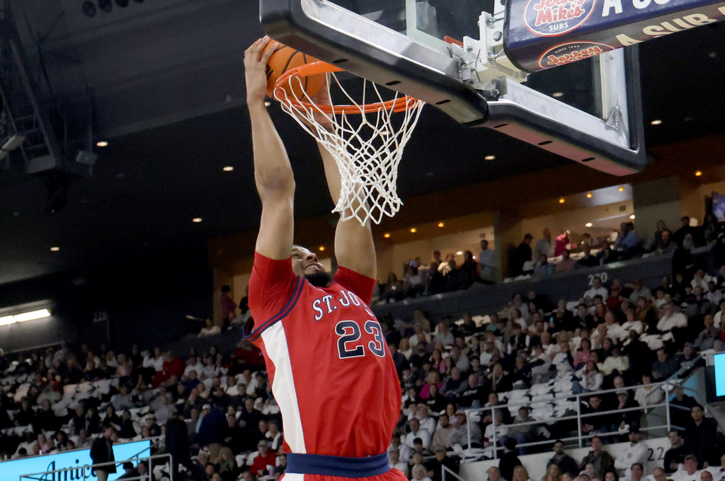 St. John's forward Bryce Hopkins (23) dunks the ball during the first half of an NCAA college basketball game against Providence, Saturday, Feb. 14, 2026, in Providence, R.I. (AP Photo/Mark Stockwell)