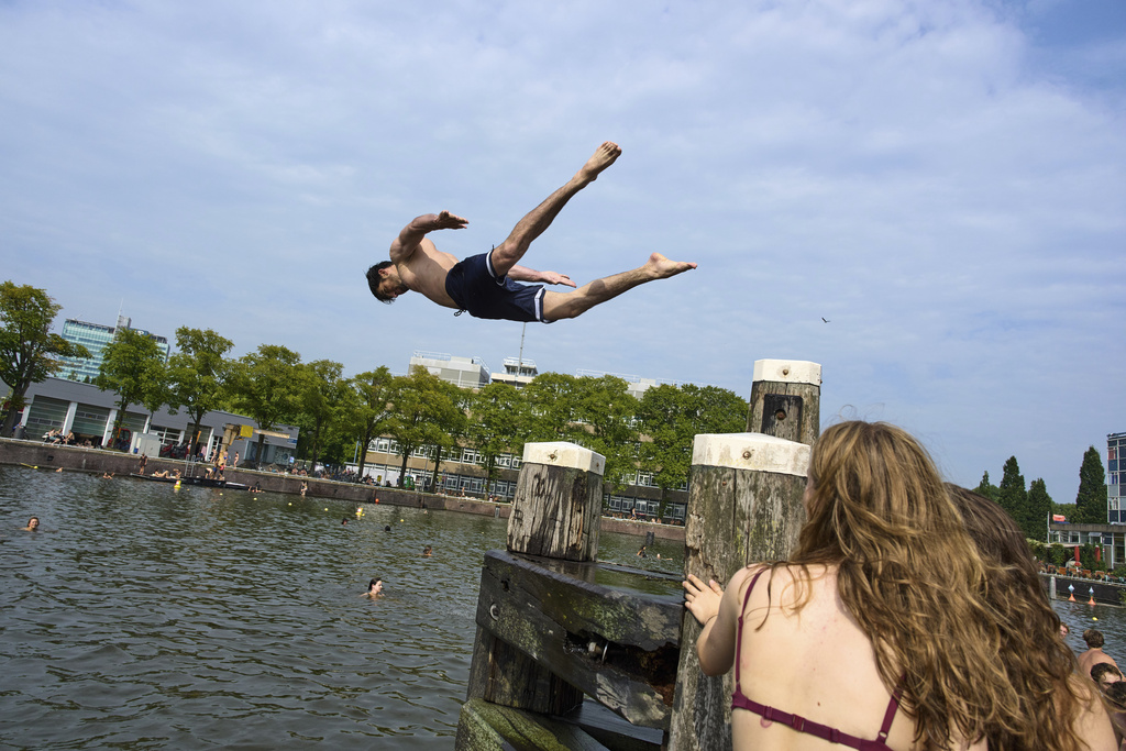 People swim to cool down during hot weather in Amsterdam, Netherlands, Wednesday, Aug. 13, 2025. (AP Photo/Peter Dejong)