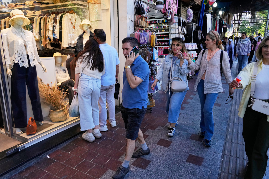 People walk along a sidewalk in northern Tehran, Iran, Sunday, May 10, 2026. (AP Photo/Vahid Salemi)