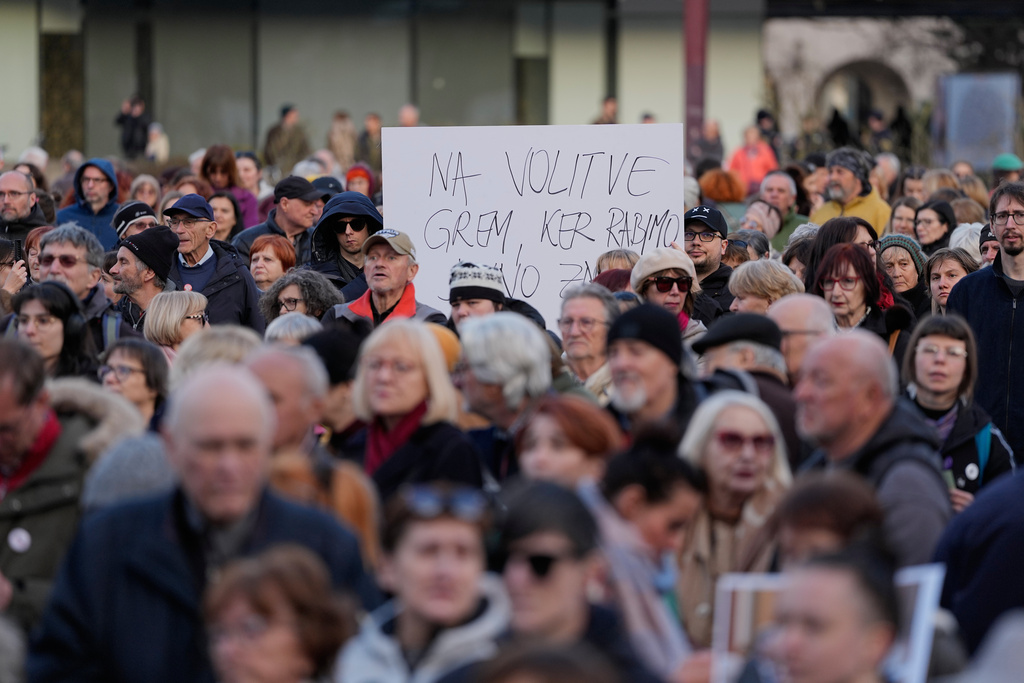 Left wing protesters denouncing foreign interference in Slovenian elections gather around a banner urging people to vote, in Ljubljana, Slovenia, Friday, March 20, 2026. (AP Photo/Darko Bandic)