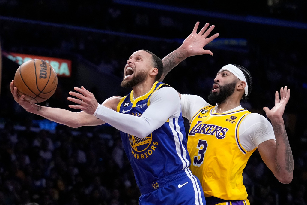 FILE - Golden State Warriors guard Stephen Curry, left, shoots as Los Angeles Lakers forward Anthony Davis defends during the first half in Game 4 of an NBA basketball Western Conference semifinal in Los Angeles, May 8, 2023. (AP Photo/Marcio Jose Sanchez, File)