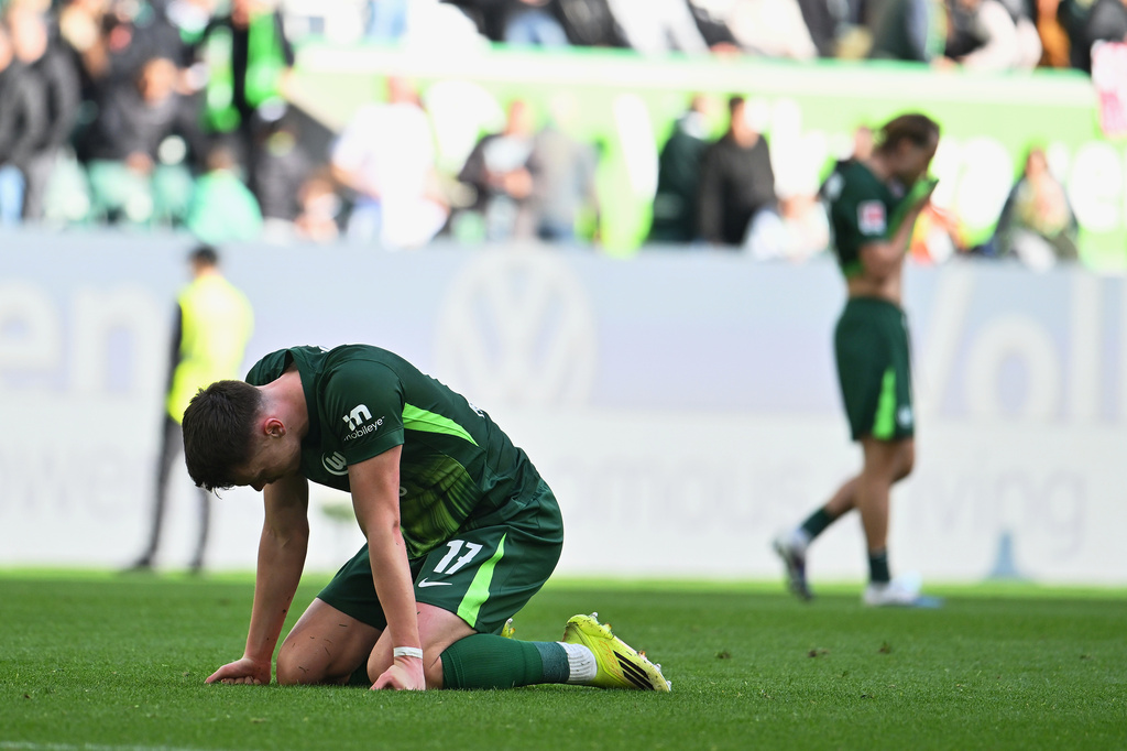 Wolfsburg's Dzenan Pejcinovic kneels on the pitch after losing the Bundesliga soccer match between Wolfsburg and Frankfurt, in Wolfsburg, Germany, Saturday April 11, 2026. (Swen Pförtner/dpa via AP)