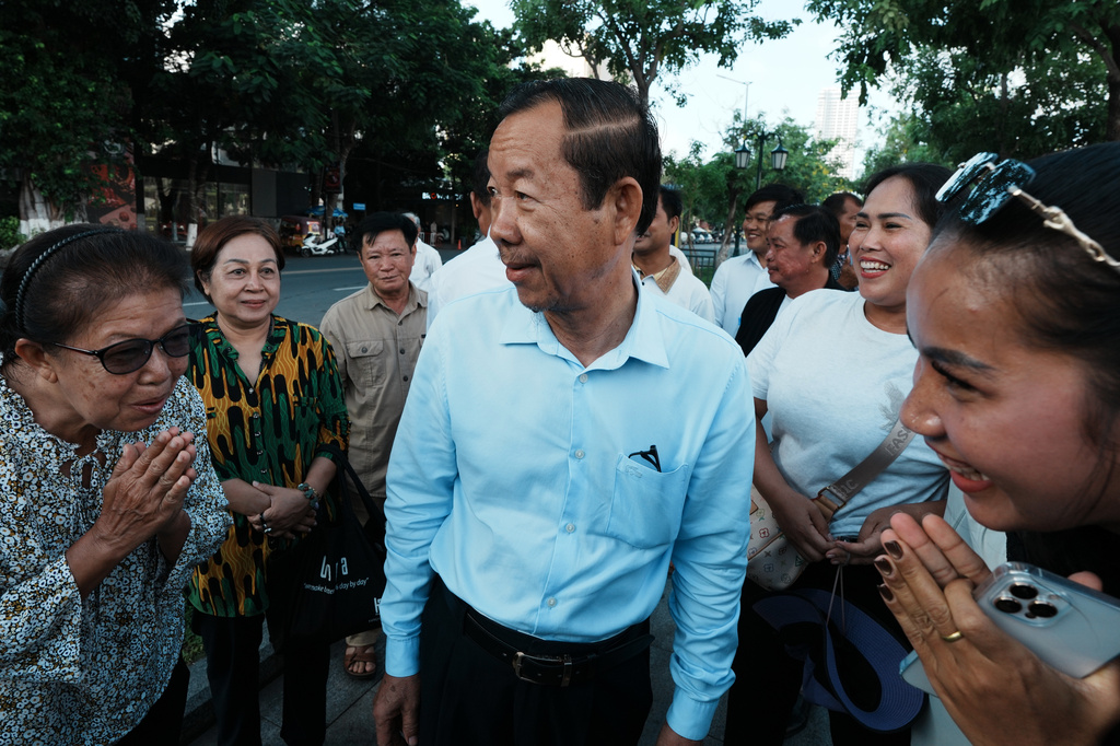 Supporters greet Rong Chhun, a prominent Cambodian opposition politician, center, as he arrives at his hearing at the Supreme Court in Phnom Penh, Cambodia, Monday, June 15, 2026. (AP Photo/Heng Sinith)