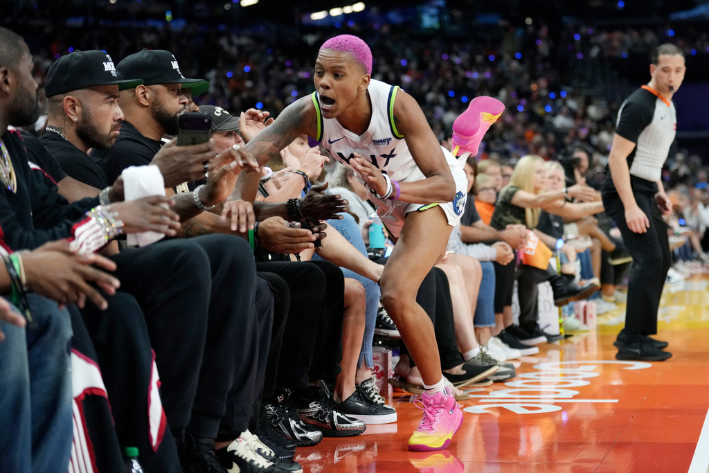 Minnesota Lynx guard Courtney Williams crashes into the crowd after trying to save a loose ball from going out of bounds during the first half of Game 3 of a WNBA basketball playoff semifinals series game against the Phoenix Mercury Friday, Sept. 26, 2025, in Phoenix. (AP Photo/Ross D. Franklin)