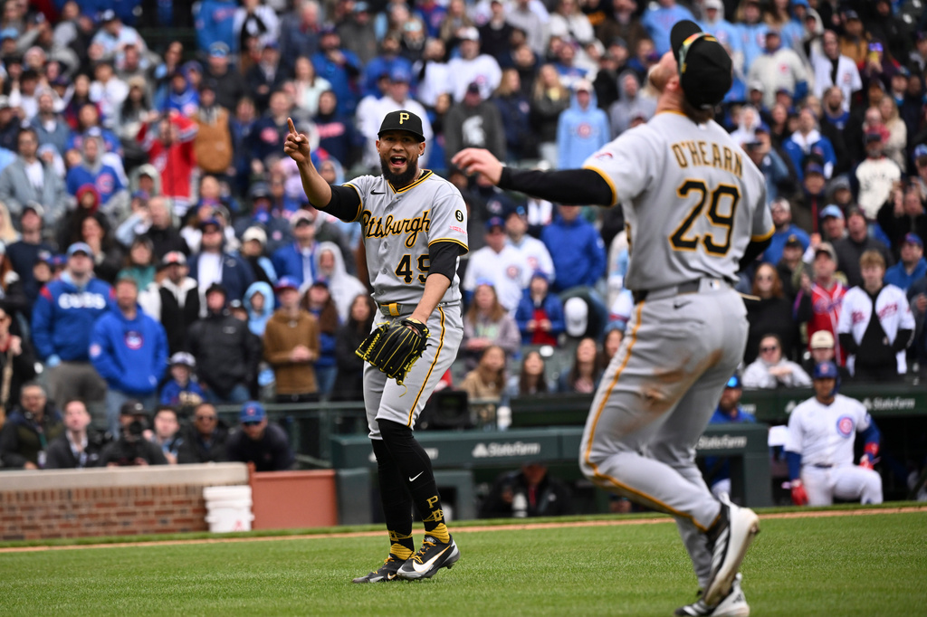Pittsburgh Pirates pitcher Yohan Ramírez (49) points to a fly ball hit by Chicago Cubs' pinch hitter Seiya Suzuki that first baseman Ryan O'Hearn (29) then caught to end a baseball game, Saturday, April 11, 2026, in Chicago. (AP Photo/Matt Marton)