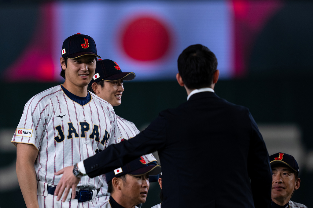 Japan's Shohei Ohtani, left, stands during a group photo session along with other team members before their practice session ahead of the World Baseball Classic games in Tokyo, Wednesday, March 4, 2026. (AP Photo/Louise Delmotte)