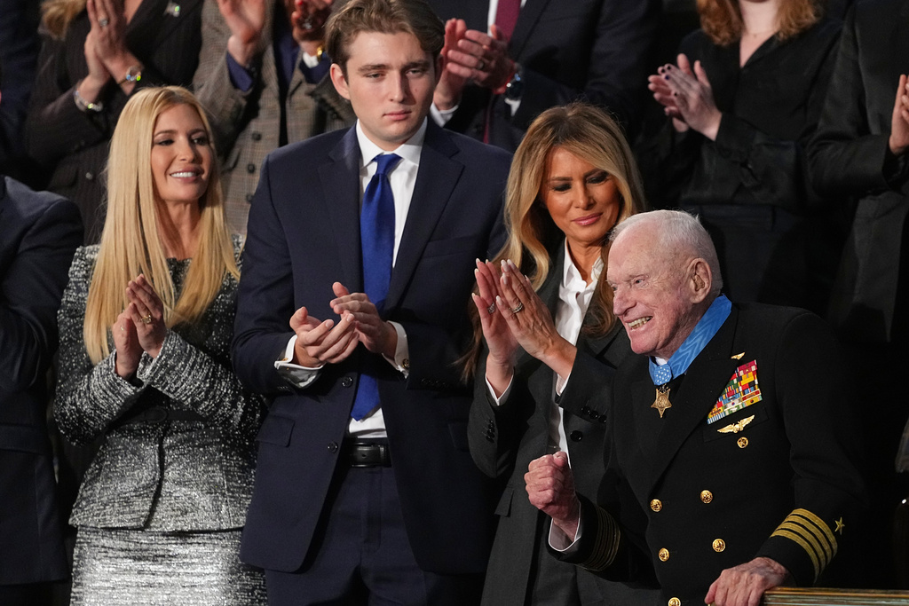 First lady Melania Trump applauds after presenting the Congressional Medal of Honor to World War II Navy pilot Capt. Royce Williams as President Donald Trump delivers the State of the Union address to a joint session of Congress in the House chamber at the U.S. Capitol in Washington, Tuesday, Feb. 24, 2026, as Ivanka Trump and Barron Trump watch. (AP Photo/Matt Rourke)