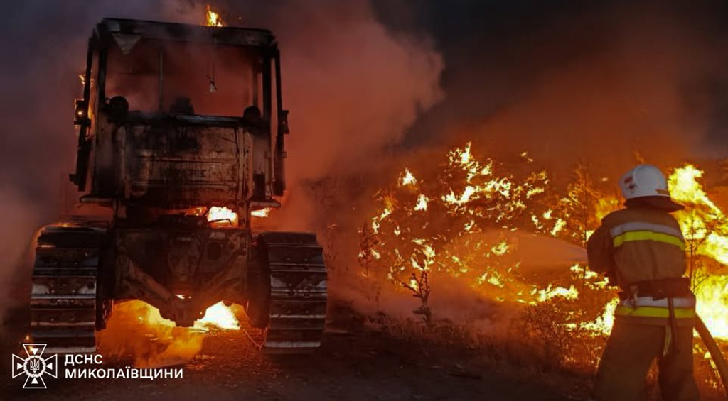 In this photo provided by the Ukrainian Emergency Services on Monday, June 29, 2026, a rescue worker puts out a fire of a tractor destroyed by a Russian strike on Mykolaiv region, Ukraine. (Ukrainian Emergency Service via AP)
