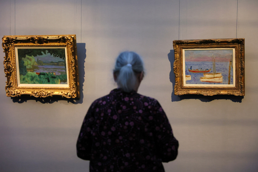 A visitor looks on the painting Lagoon on the Seine, left, and White Boots from Pierre Bonnard at a press preview for the exhibition "The Scharf Collection: Goya – Monet – Cezanne – Bonnard – Grosse" at the Alte Nationalgalerie museum in Berlin, Wednesday, Oct. 22, 2025. (AP Photo/Maryam Majd)