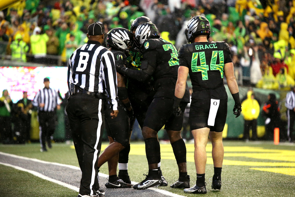 Oregon running back Jordon Davison, second from left, is congratulated after his touchdown during the first half of an NCAA college football game against Wisconsin, Saturday, Oct. 25, 2025, in Eugene, Ore. (AP Photo/Lydia Ely)