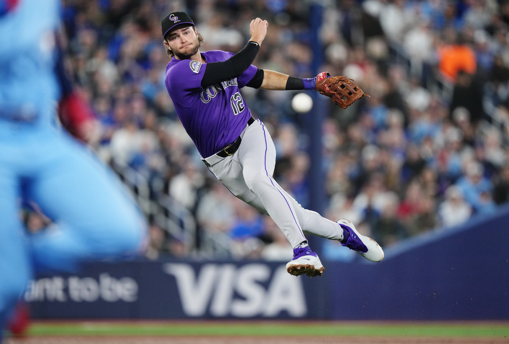 Colorado Rockies third baseman Kyle Karros (12) throws to first base during third inning of a baseball game against the Toronto Blue Jays in Toronto on Tuesday, March 31, 2026. (Nathan Denette/The Canadian Press via AP)