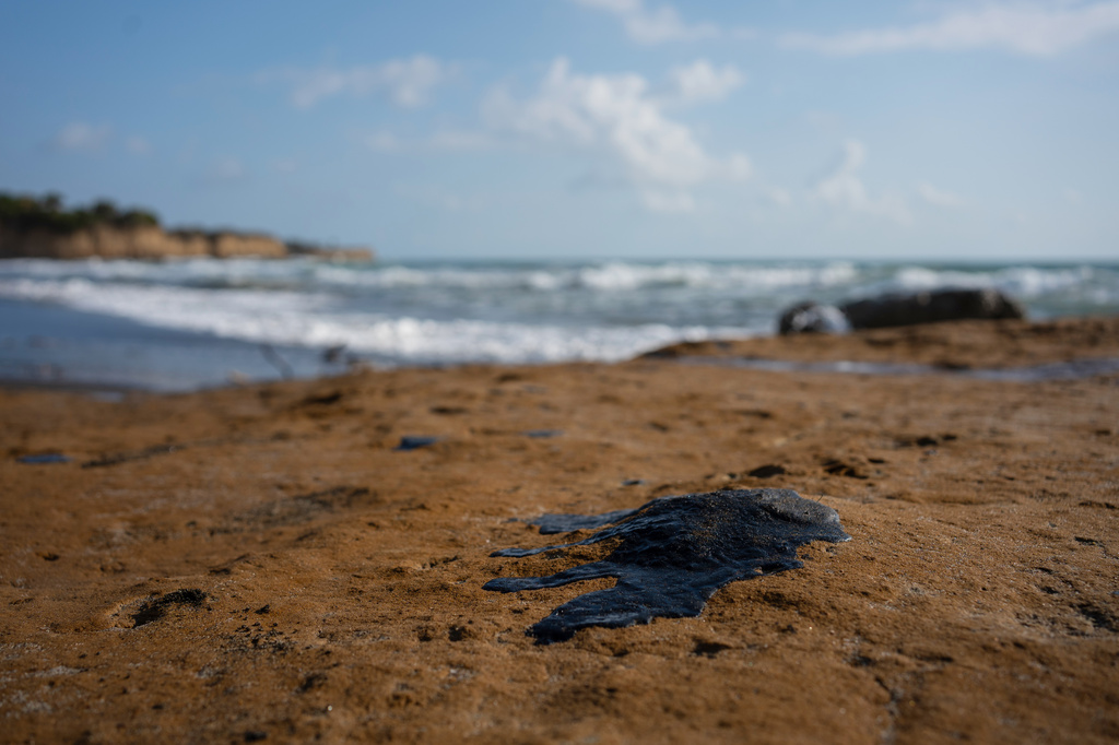 Clumps of oil residue stain the shore after fishing outings were suspended because of an oil spill that Mexican authorities said originated from an unidentified vessel and two natural oil seeps along the Gulf coast in Salinas, Mexico, Thursday, March 26, 2026. (AP Photo/Felix Marquez)
