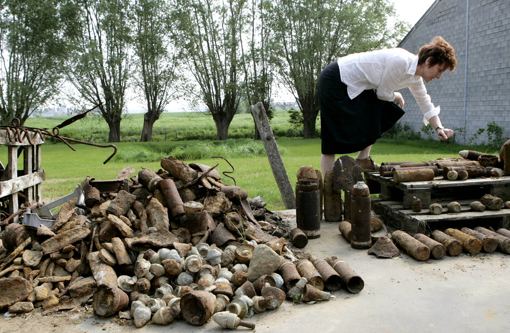 FILE - Charlotte Cardoen-Descamps points out different types of World War I shells that were found on her farm in Poelkapelle, Belgium, May 4, 2007, in what is known as the "iron harvest". (AP Photo/Virginia Mayo, File)