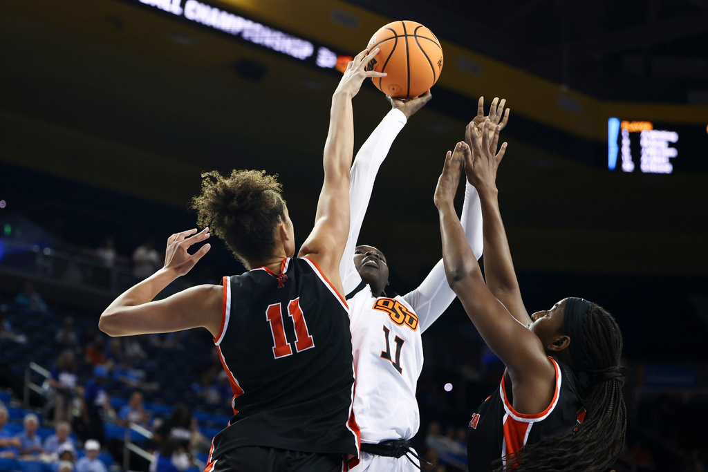 Princeton forward Taylor Charles (11) blocks a shot against Oklahoma State forward Achol Akot (11) as guard Fadima Tall, right, defends during the first half in the first round of the NCAA college basketball tournament, Saturday, March 21, 2026, in Los Angeles. (AP Photo/Jessie Alcheh)