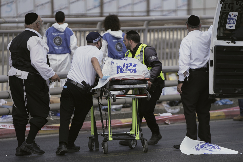 Israeli Zaka rescue and recovery team carry the body of a victim at the scene of shooting attack carried out by two Palestinian gunmen, in which several people were killed and others injured at a bus stop in Jerusalem, Monday, Sept. 8, 2025. (AP Photo/Mahmoud Illean)