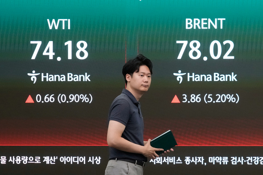 A currency trader passes by a screen showing international oil prices at the foreign exchange dealing room of the Hana Bank headquarters in Seoul, South Korea, Thursday, July 9, 2026. (AP Photo/Ahn Young-joon)