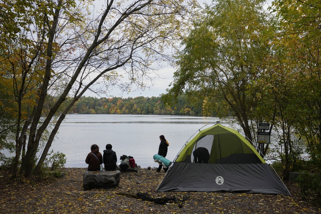 A couple pack their belongings after they spent a night in a tent by the Lake Wilcox in Richmond Hill, Ontario, Canada, Monday, Oct. 20, 2025. (AP Photo/Kamran Jebreili)