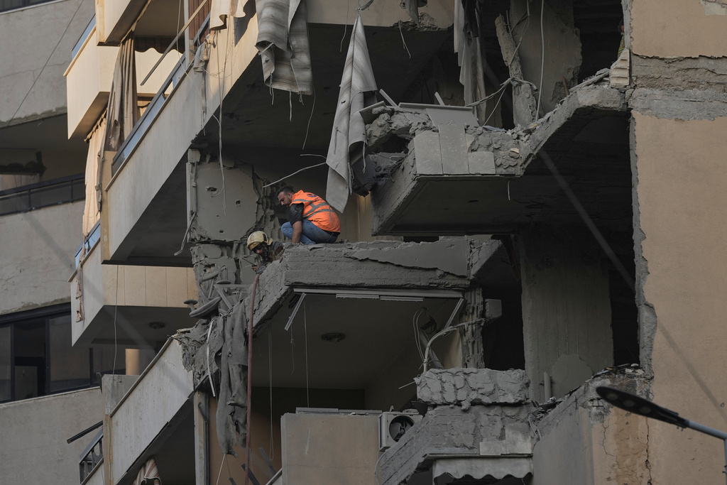 Civil defense workers inspect the damage at an apartment building hit during an Israeli airstrike on Dahiyeh in the southern suburb of Beirut, Sunday Nov. 23, 2025. (AP Photo/Bilal Hussein)