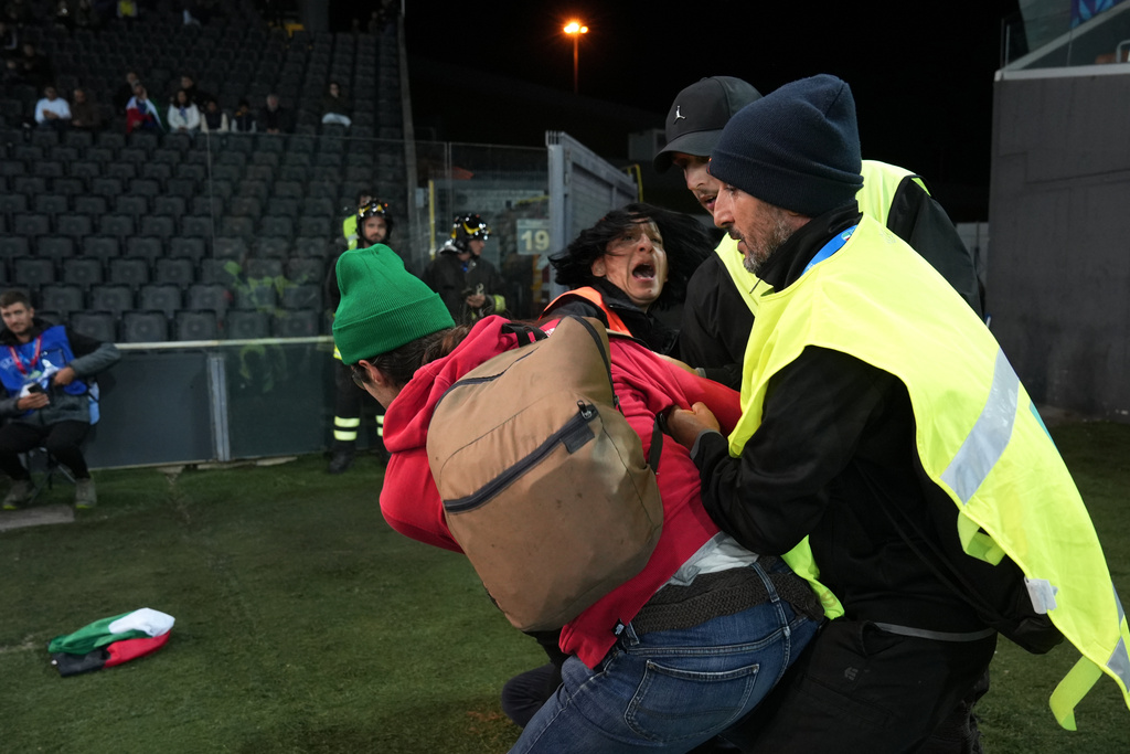 Security remove protesters with Palestinian flags during the World Cup 2026 Group I qualifying soccer match between Italy and Israel at the Friuli Stadium in Udine, Italy, Tuesday, Oct. 14, 2025. (Massimo Paolone/LaPresse via AP)