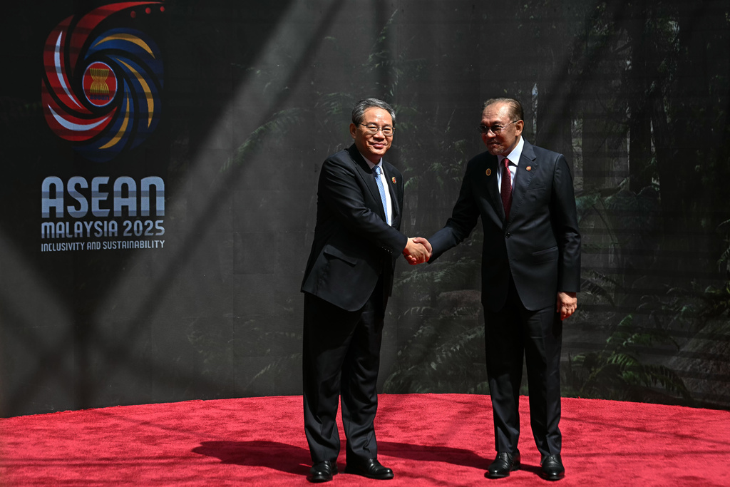China's Premier Li Qiang, left, shakes hands with Malaysia's Prime Minister Anwar Ibrahim as he arrives at the Kuala Lumpur Convention Centre to attend the 47th Association of Southeast Asian Nations (ASEAN) summit in Kuala Lumpur, Malaysia, Monday, Oct. 27, 2025. (Lillian Suwanrumpha/Pool Photo via AP)