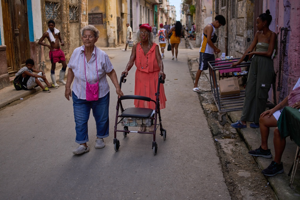 Women walk down the street during a blackout in Havana, Cuba, Thursday, March 5, 2026. (AP Photo/Ramon Espinosa)