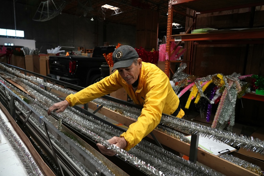 Mark Latino, CEO of Lee Display, works with a machine that makes tinsel brush for artificial Christmas trees at the company's warehouse, in Fairfield, Calif., Tuesday, Dec. 9, 2025. (AP Photo/Terry Chea)