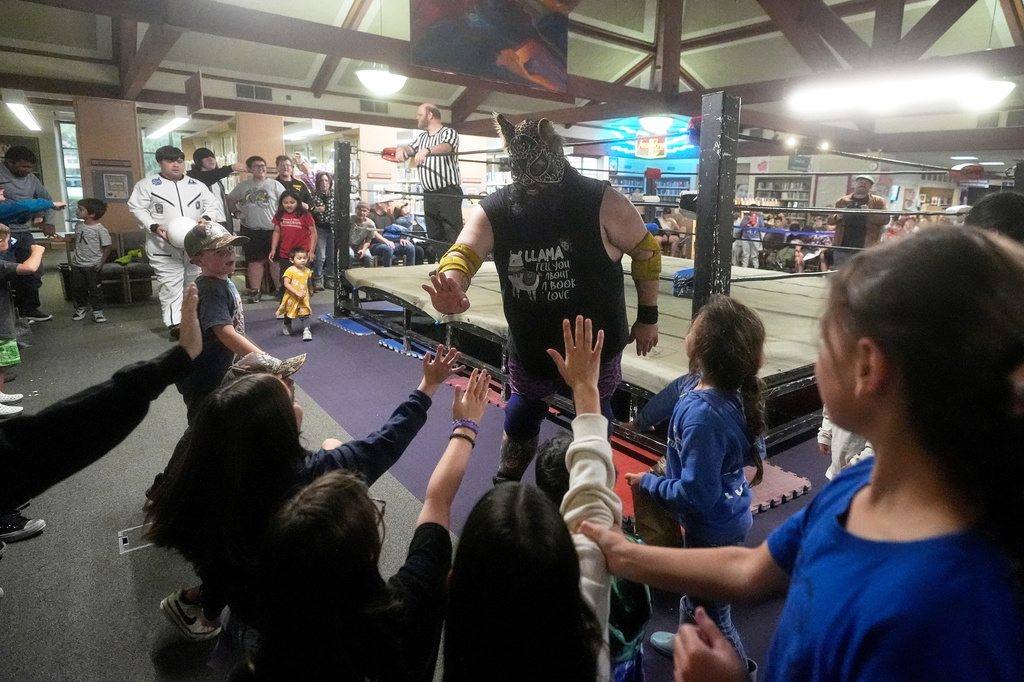 Wrestler Llama Jack greets fans during a Lucha Libro pro wrestling event at Benicia Public Library Saturday, May 2, 2026, in Benicia, Calif. (AP Photo/Jeff Chiu)