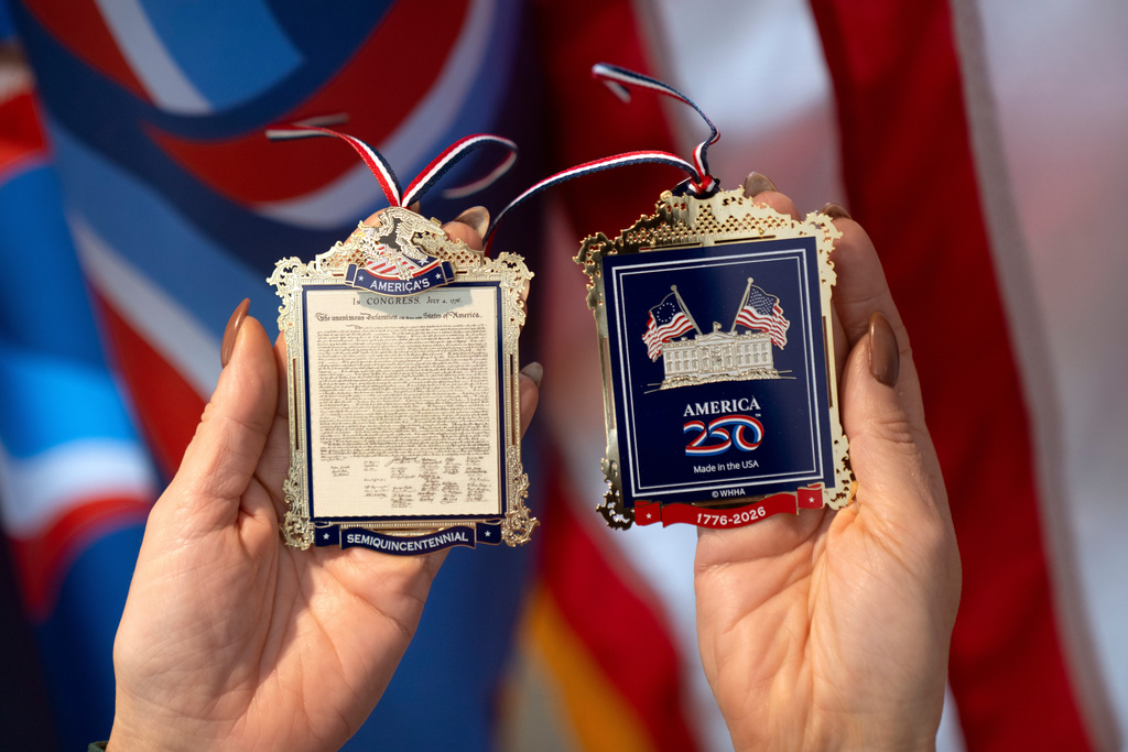 Jennifer Condon, Executive Vice President of America250, displays the front and back of a commemorative ornament released by America250 as part of events leading up to the 250th anniversary of the signing of the Declaration of Independence in 1776, Thursday, Nov. 13, 2025, in Washington. (AP Photo/Mark Schiefelbein)