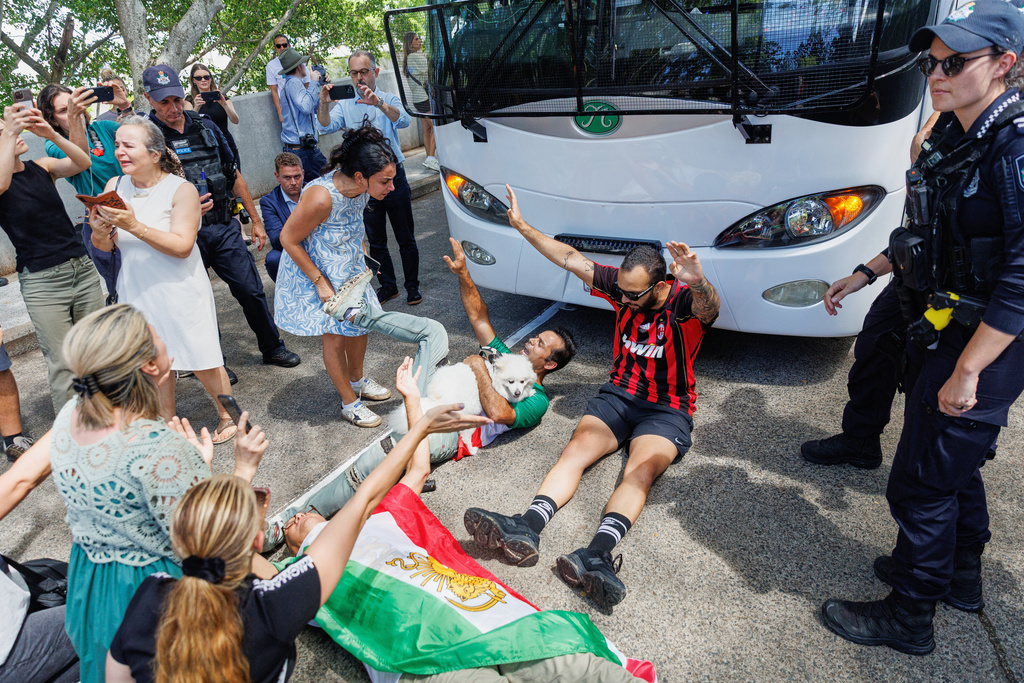 Protesters block the progress of a bus believed to be carrying the Iranian women's soccer team as it attempts to leave a hotel on the Gold Coast, Australia, Tuesday, March 10, 2026. (Russell Freeman/AAPImage via AP)